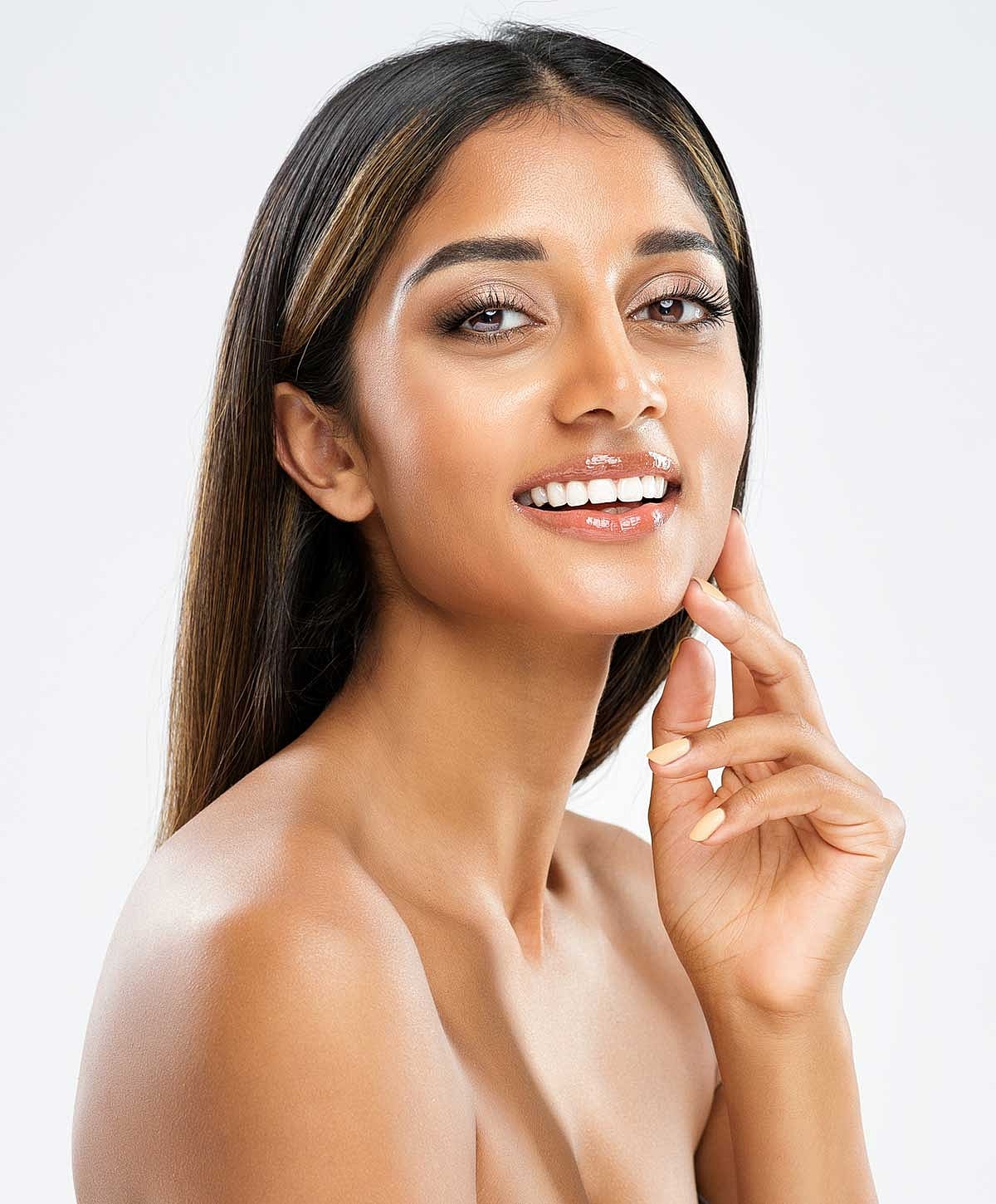 Smiling woman with long hair and clear skin.
