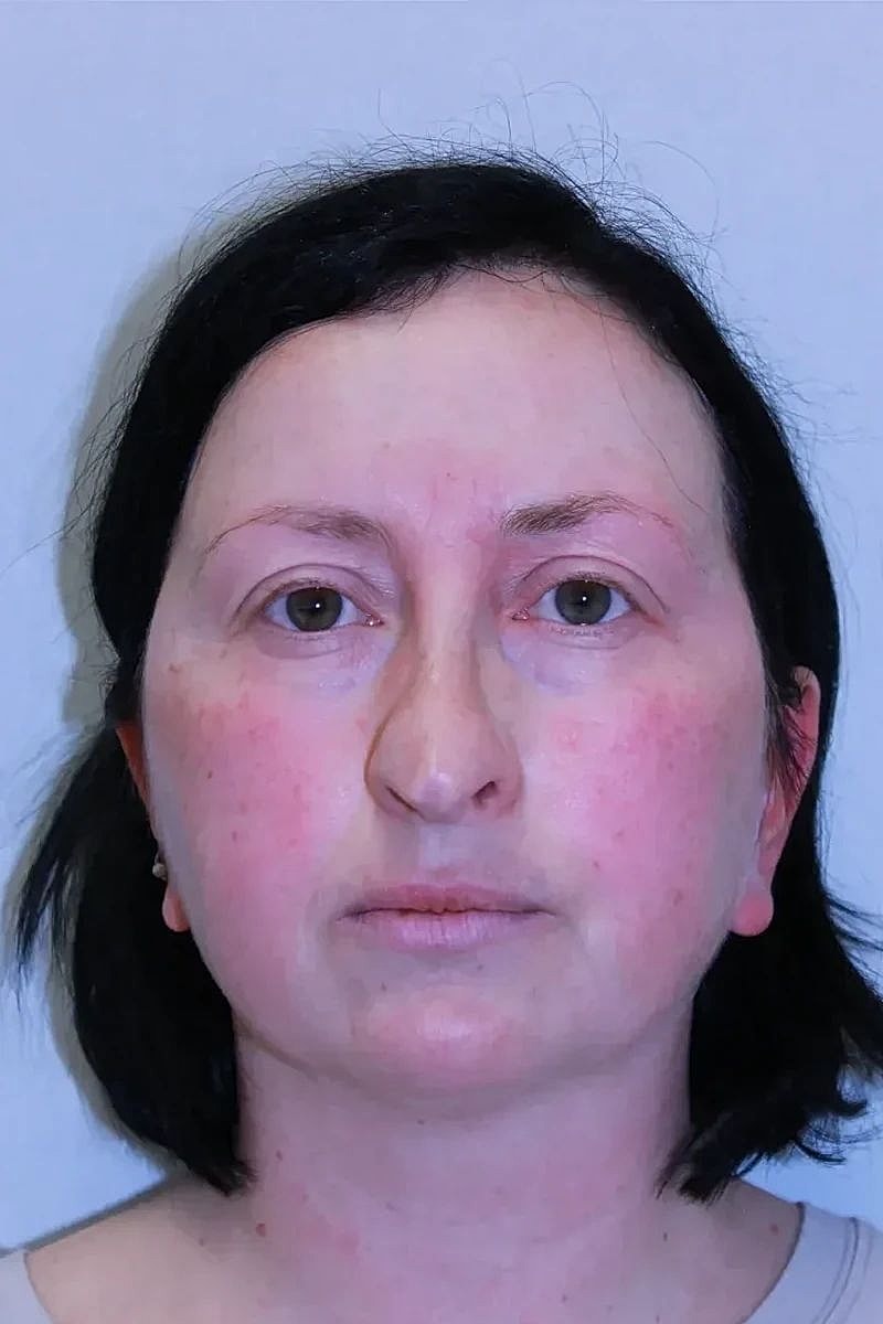 Woman with short dark hair, neutral expression.