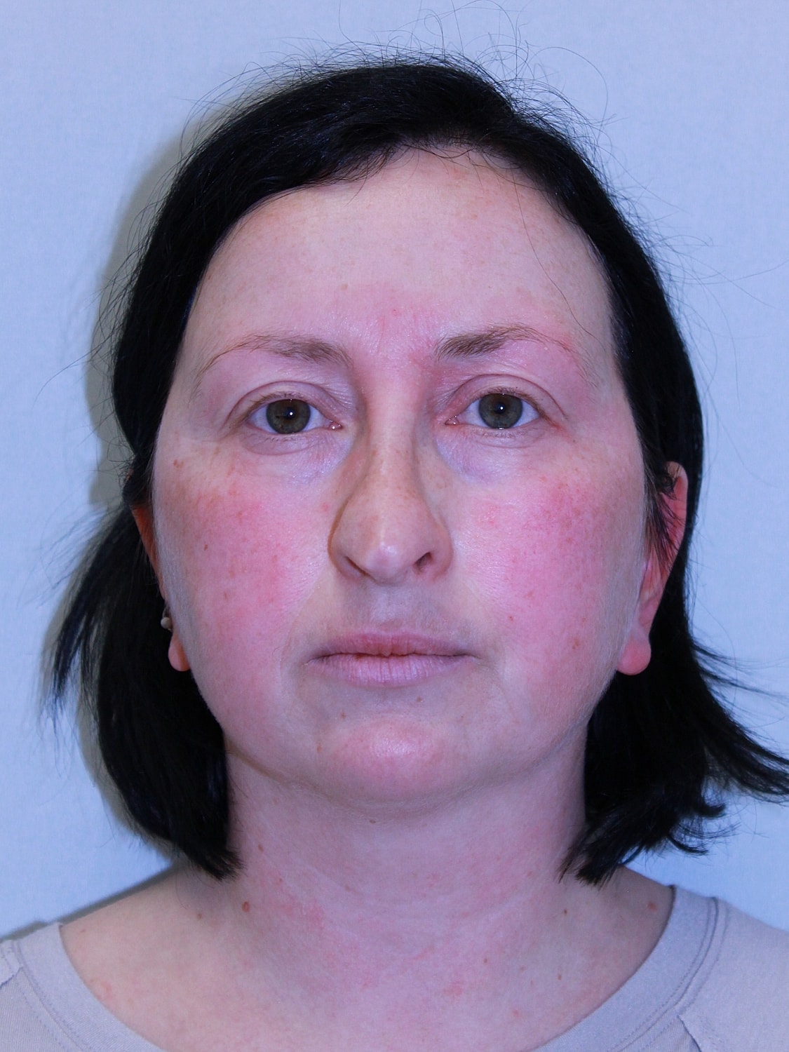 Woman with medium-length black hair, neutral expression.