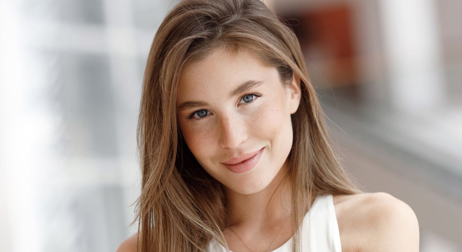 Smiling young woman with long, wavy hair.