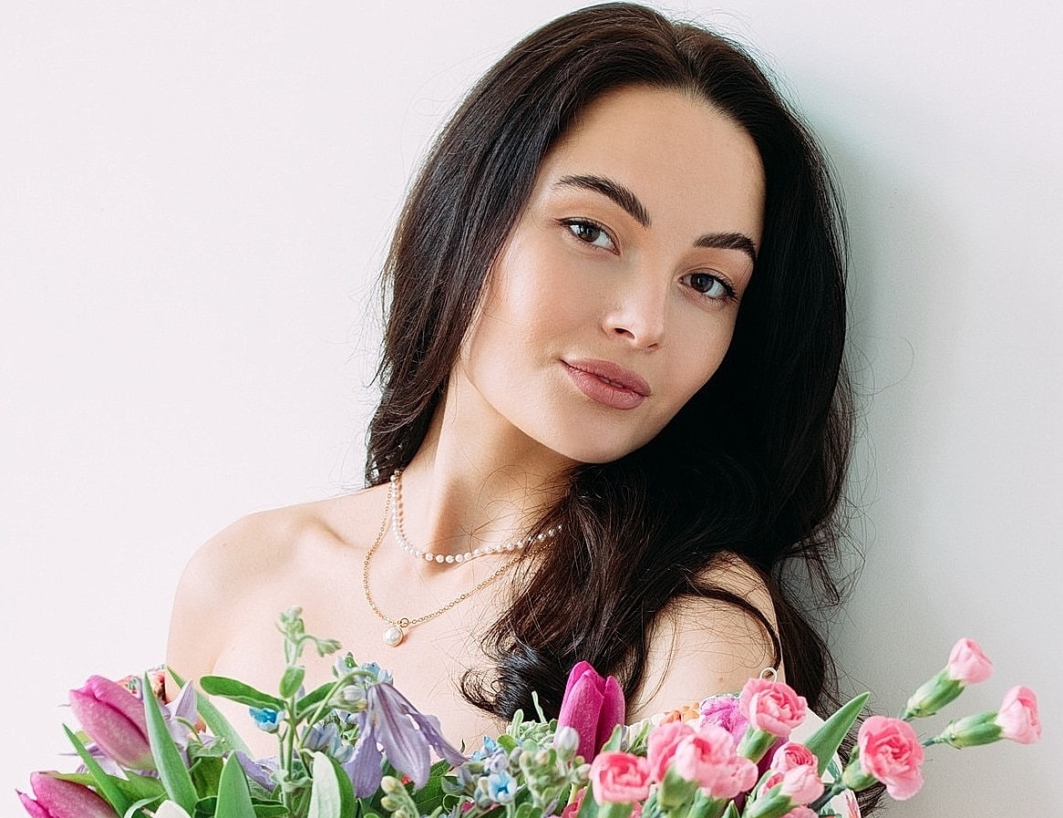 Woman holding a vibrant bouquet of flowers.