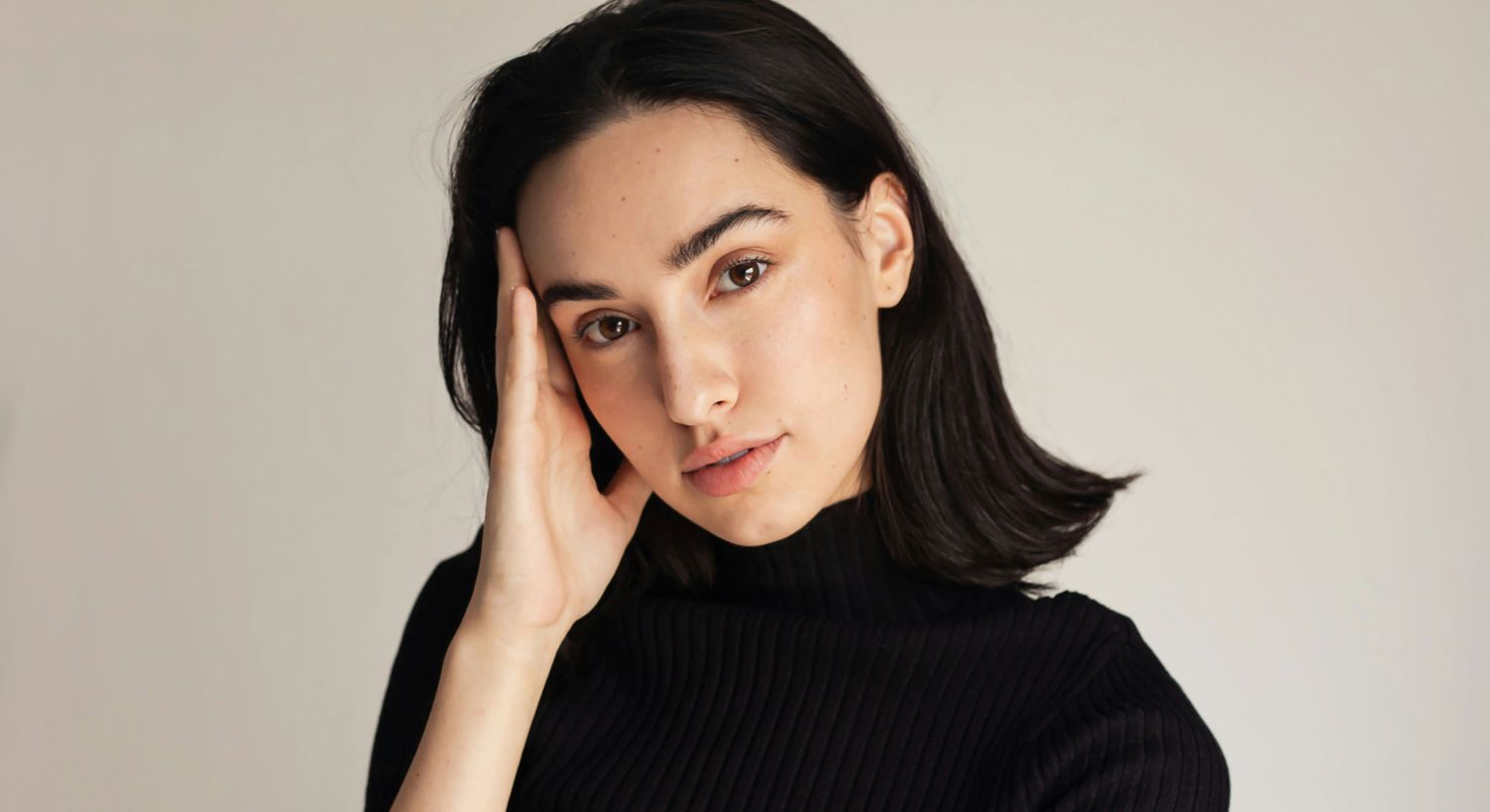 Person with dark hair in a black sweater.